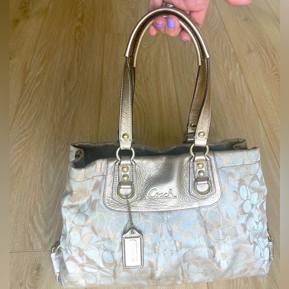 Medium sized Coach purse. Lt tan & gold w/ purple interior. All zippers work.